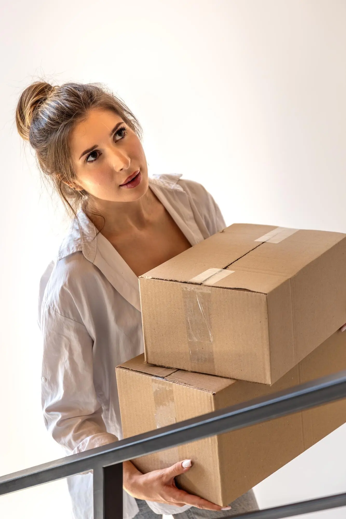 Stilvolles Mädchen trägt Pakete nach oben und schaut in die Kamera, Online-Shopping.